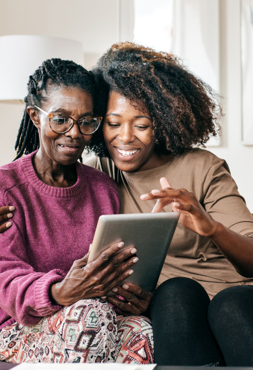 caregiver and elderly woman readiong together