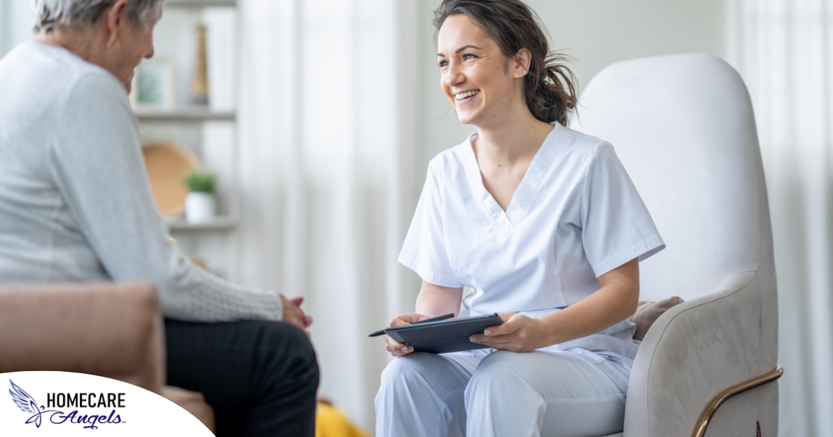 A woman smiles and enjoys her caregiving job as she writes notes down with a client.