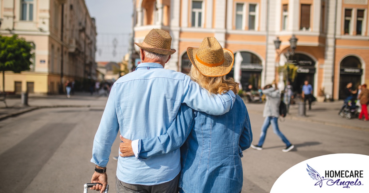 2 older adults hug while on vacation representing the successful outing that can still happen while caring for elderly loved ones.