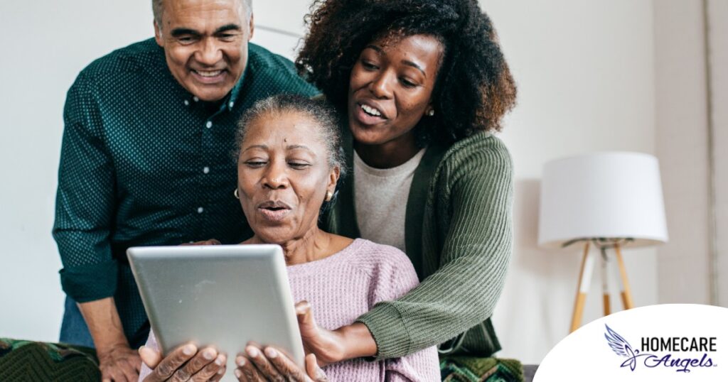 A daughter looks at a tablet with her older parents, representing technology and how ti can help with aging in place.